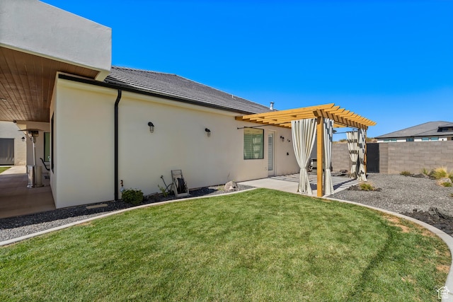 back of property with stucco siding, a pergola, a patio area, fence, and a lawn
