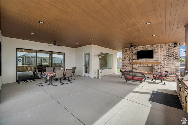 view of patio / terrace with outdoor dining space, a ceiling fan, and an outdoor brick fireplace