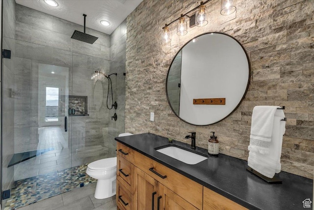 bathroom featuring tile patterned floors, toilet, a shower stall, and vanity
