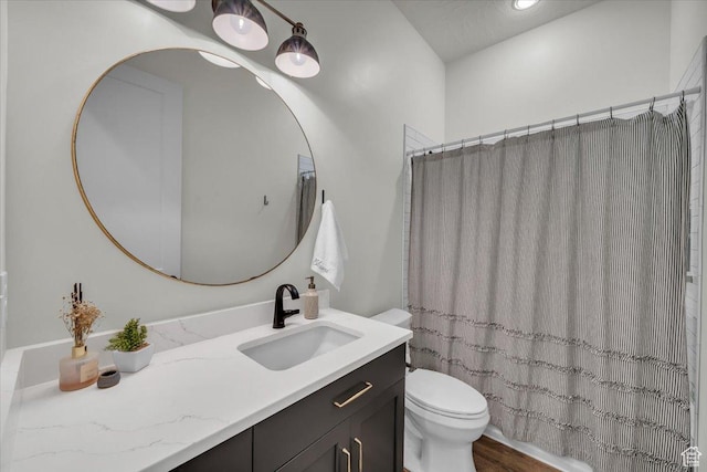 bathroom with toilet, wood finished floors, vanity, and a shower with curtain