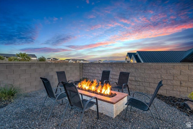 patio terrace at dusk with a fire pit and fence
