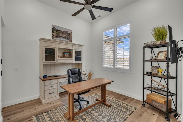 office space featuring visible vents, ceiling fan, light wood-type flooring, and baseboards