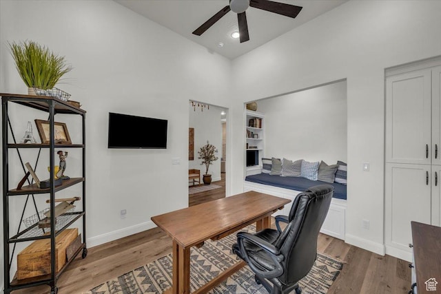 office space featuring light wood-type flooring, a ceiling fan, and baseboards