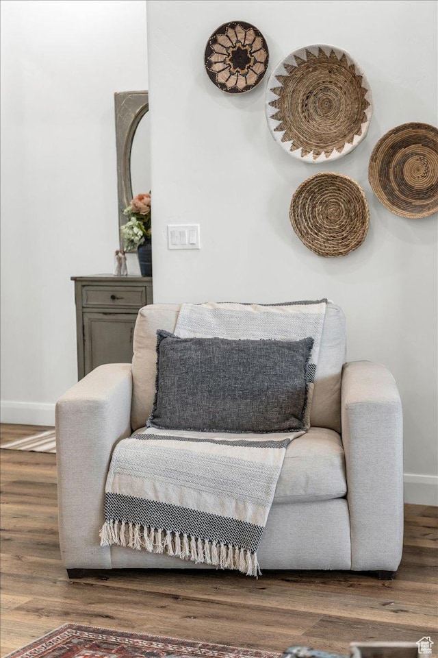 sitting room with baseboards and wood finished floors