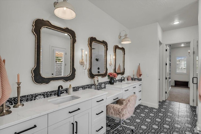 bathroom featuring vanity, baseboards, and walk in shower
