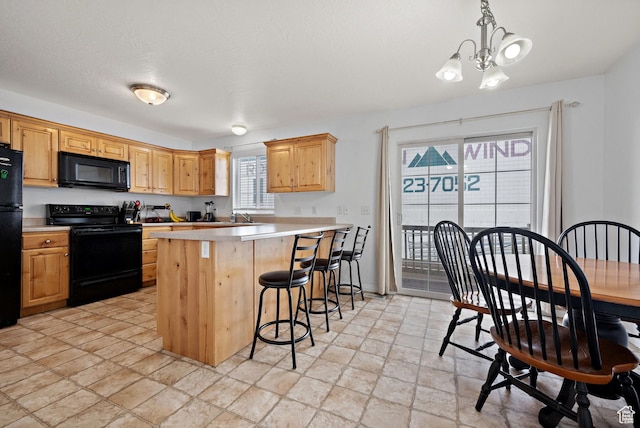 kitchen featuring an inviting chandelier, light countertops, decorative light fixtures, a breakfast bar area, and black appliances