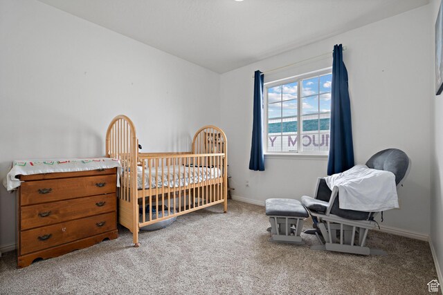 bedroom featuring carpet flooring, baseboards, and a nursery area