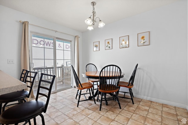 dining area featuring baseboards, an inviting chandelier, and stone finish flooring