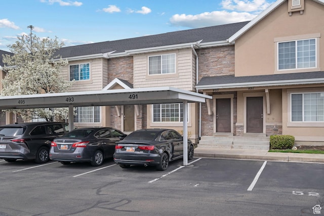 view of front of property with stone siding and covered parking