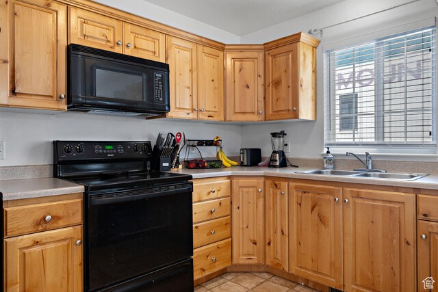 kitchen featuring a sink, light countertops, and black appliances