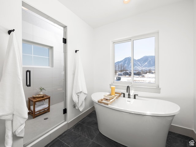 full bathroom featuring a shower stall, a soaking tub, a mountain view, and a healthy amount of sunlight