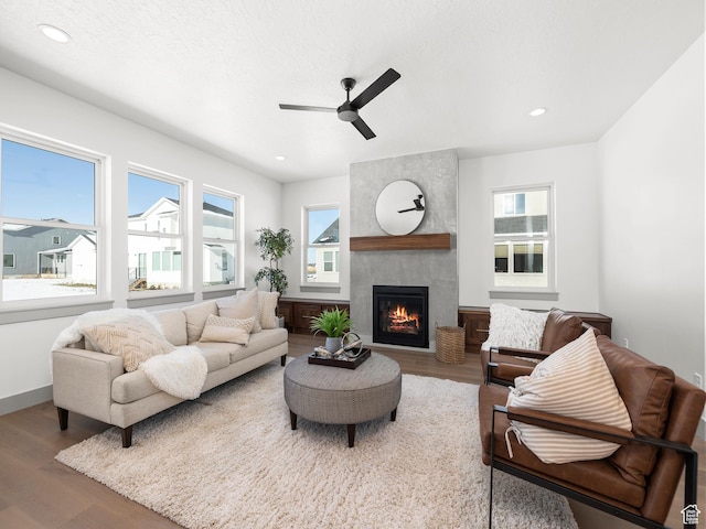 living area with baseboards, ceiling fan, a fireplace, recessed lighting, and wood finished floors