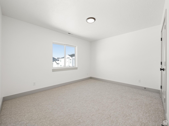 unfurnished room featuring light carpet, visible vents, and baseboards