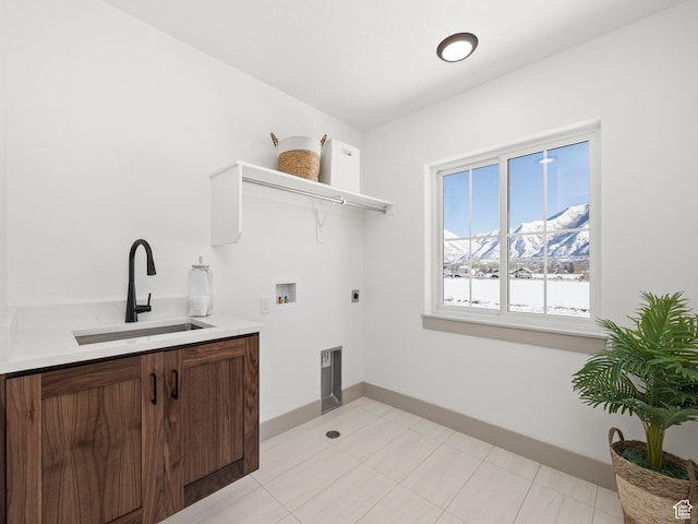 clothes washing area with baseboards, electric dryer hookup, laundry area, hookup for a washing machine, and a sink