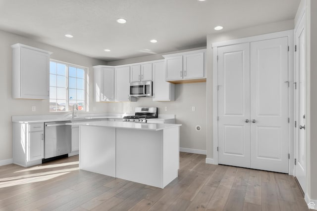 6633 N Price, Eagle Mountain, UT 84005 - kitchen featuring appliances with stainless steel finishes, light wood finished floors, light countertops, and white cabinetry