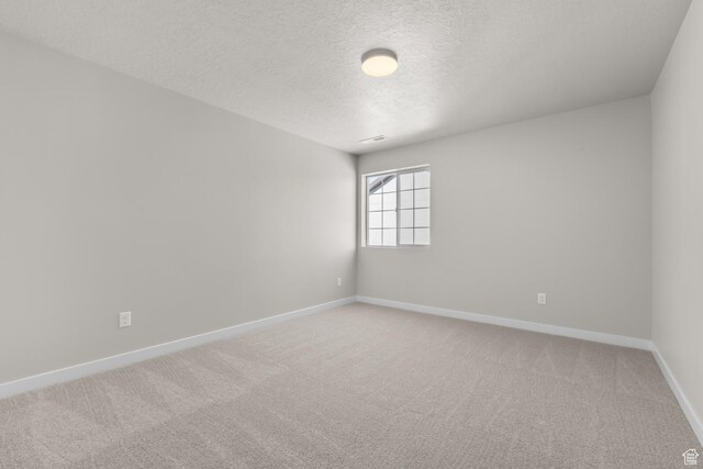 6633 N Price, Eagle Mountain, UT 84005 - empty room featuring light carpet, baseboards, and a textured ceiling