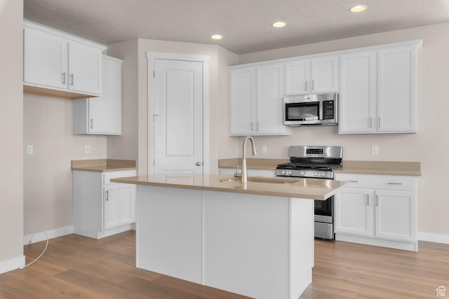 6624 W Prairie Fire Ln, Herriman, UT 84096 - kitchen featuring a sink, white cabinets, light wood finished floors, and stainless steel appliances