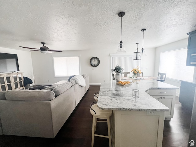 2770 S 9500 E, Jensen, UT 84035 - kitchen with a large island, ceiling fan, light stone countertops, and dark wood-style floors
