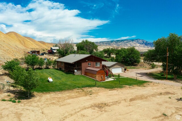 2770 S 9500 E, Jensen, UT 84035 - exterior space featuring a mountain view, a detached garage, dirt driveway, an outbuilding, and a yard