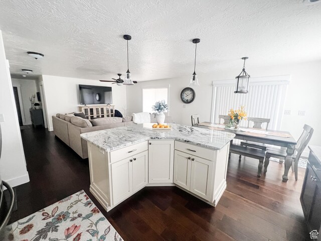 2770 S 9500 E, Jensen, UT 84035 - kitchen featuring decorative light fixtures, dark wood-style flooring, a ceiling fan, and light stone counters