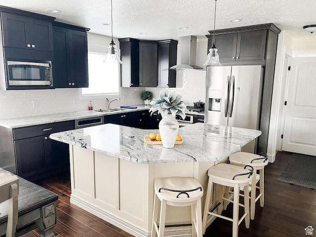 2770 S 9500 E, Jensen, UT 84035 - kitchen featuring dark wood-style flooring, wall chimney range hood, a sink, stainless steel appliances, and a kitchen island