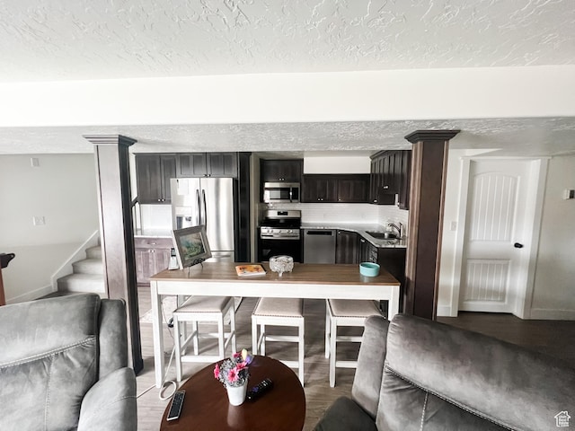2770 S 9500 E, Jensen, UT 84035 - interior space featuring a sink, a textured ceiling, wood finished floors, stainless steel appliances, and decorative backsplash