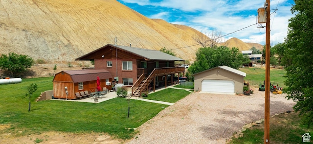 2770 S 9500 E, Jensen, UT 84035 - exterior space featuring a front lawn, stairs, a patio area, an outbuilding, and a garage