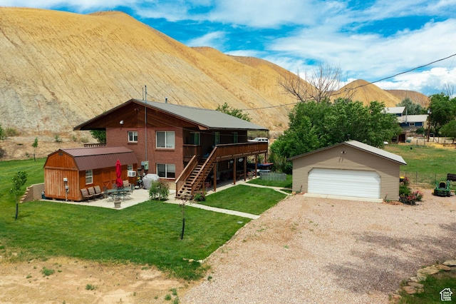2770 S 9500 E, Jensen, UT 84035 - exterior space with a front lawn, a mountain view, an outbuilding, and a detached garage