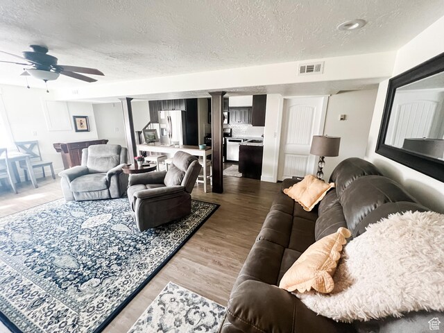 2770 S 9500 E, Jensen, UT 84035 - living area featuring visible vents, a ceiling fan, light wood-style floors, a textured ceiling, and ornate columns