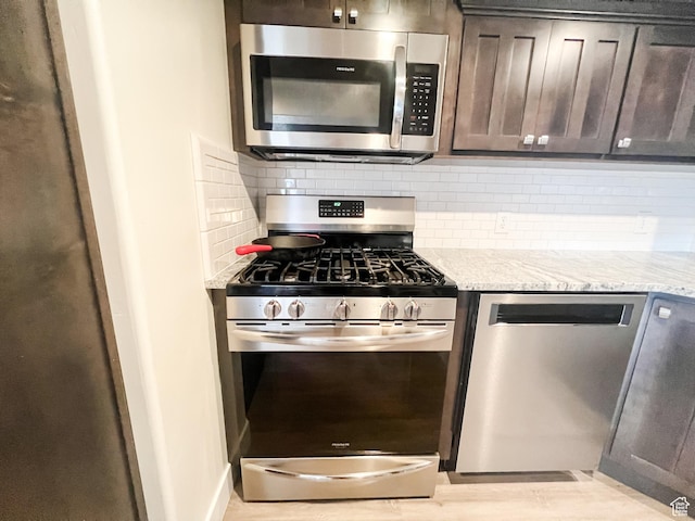 2770 S 9500 E, Jensen, UT 84035 - kitchen featuring dark brown cabinets, backsplash, light stone counters, and appliances with stainless steel finishes