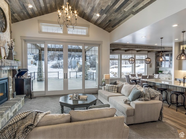 living room featuring a healthy amount of sunlight, a fireplace, wood finished floors, and a notable chandelier