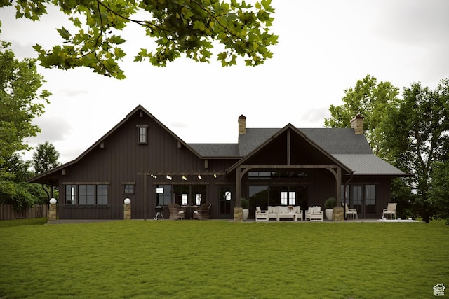 back of house featuring a yard, a patio, an outdoor living space, and a chimney