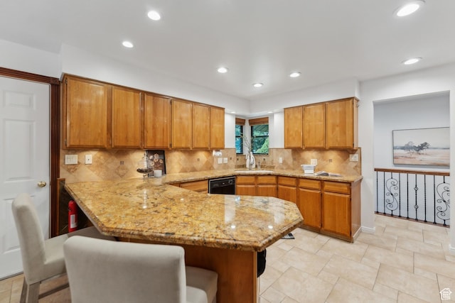 kitchen featuring a peninsula, brown cabinets, a sink, and black dishwasher