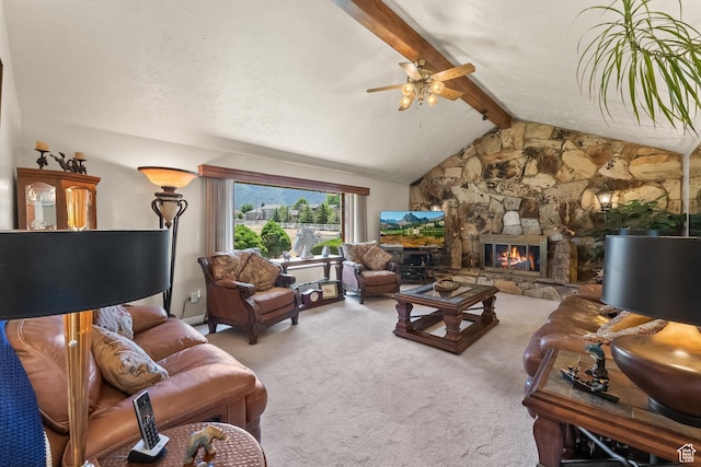 carpeted living room with a stone fireplace, ceiling fan, lofted ceiling with beams, and a textured ceiling
