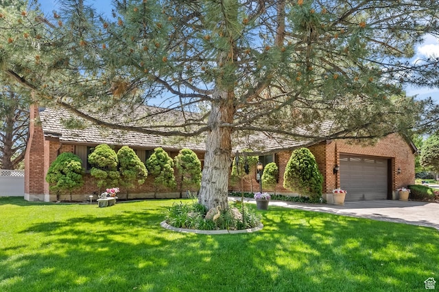 view of front facade featuring brick siding, a front lawn, an attached garage, and driveway