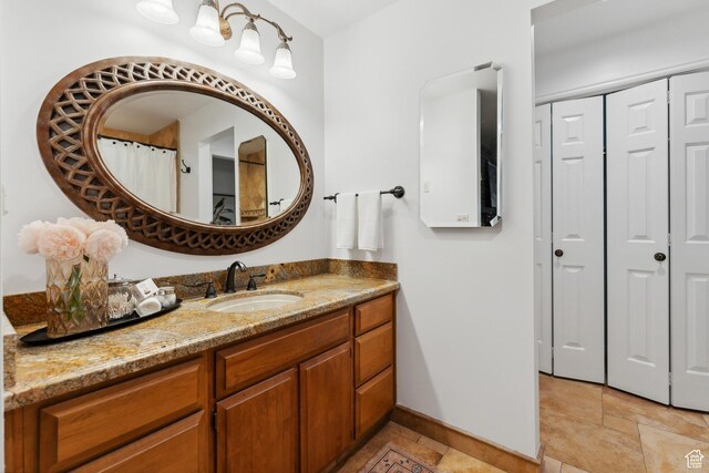 bathroom featuring a closet, baseboards, and vanity