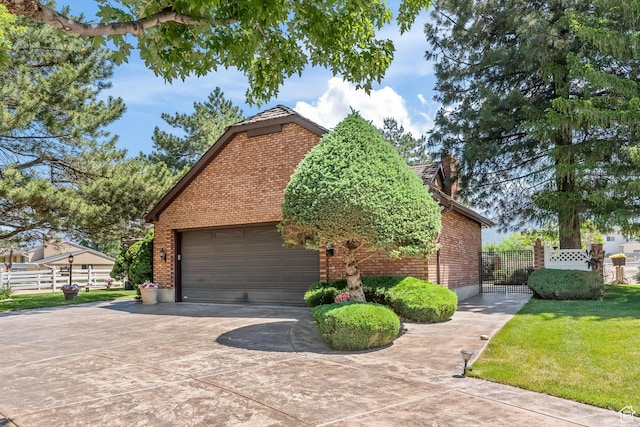 view of side of home featuring a garage, brick siding, driveway, and fence