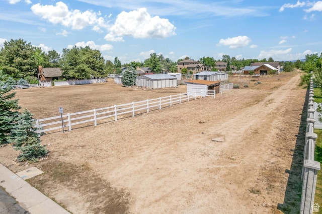 view of yard featuring an outbuilding, fence, and an exterior structure