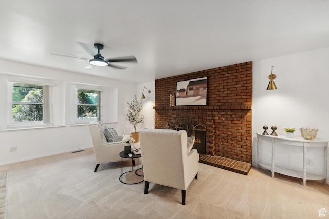 living area with a fireplace, carpet, a ceiling fan, visible vents, and baseboards