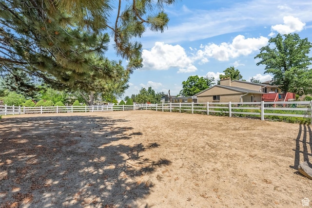 view of yard featuring a rural view, fence, and an enclosed area