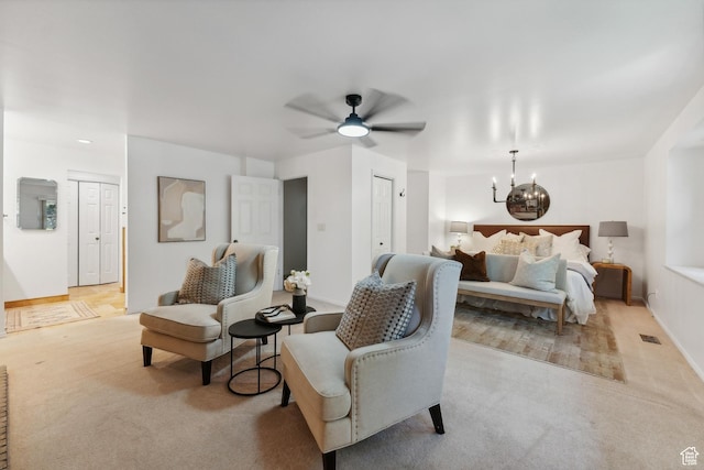 carpeted bedroom with visible vents, baseboards, and ceiling fan with notable chandelier