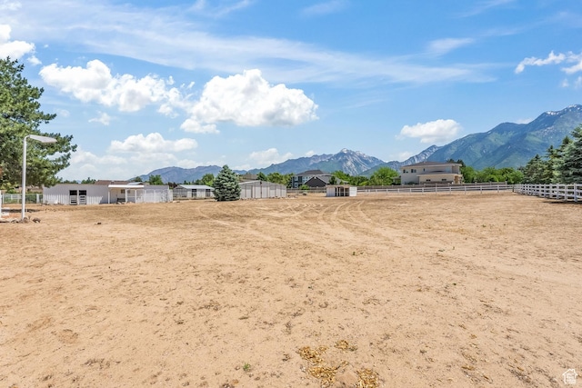 view of yard featuring fence, an enclosed area, and a mountain view