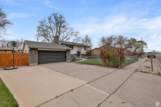 view of front of property with concrete driveway, brick siding, a chimney, and a fenced front yard