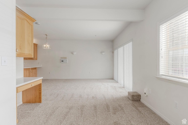 11035 S Grapevine Cv Unit 101, Sandy, UT 84070 - unfurnished living room with light colored carpet, baseboards, beam ceiling, and a wealth of natural light