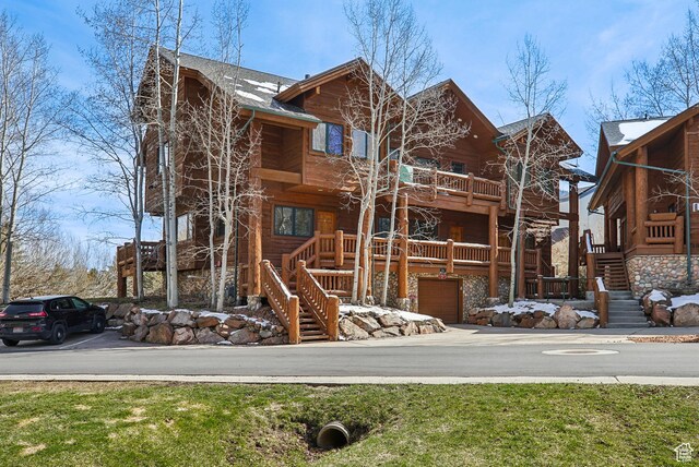 exterior space featuring roof with shingles, an attached garage, and stairs