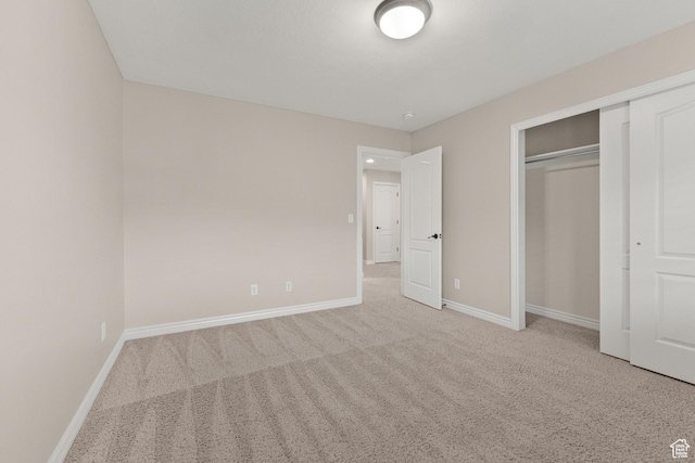 unfurnished bedroom featuring a closet, carpet flooring, and baseboards