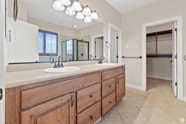 full bathroom with tile patterned floors, double vanity, a sink, and a stall shower