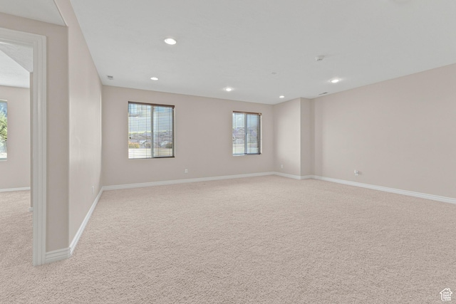 empty room with light carpet, recessed lighting, and baseboards
