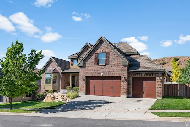 view of front of home featuring concrete driveway, a garage, fence, and brick siding