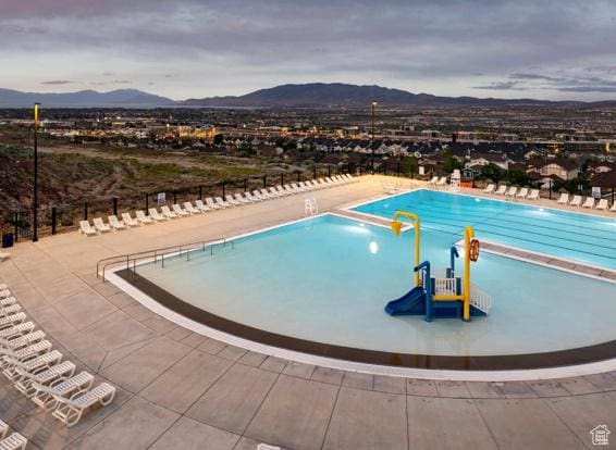 community pool featuring a mountain view and fence